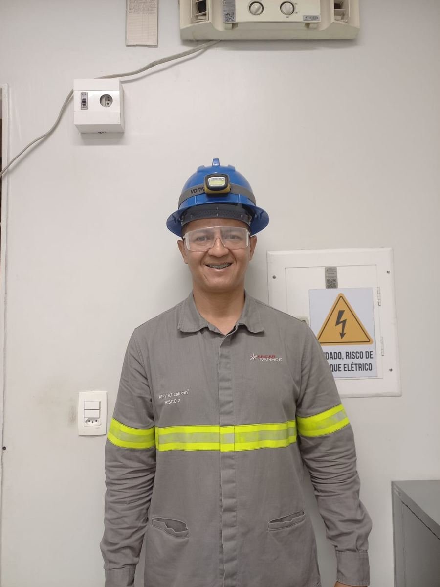 Eletricista da Só no Braço de uniforme e capacete ao lado de quadro elétrico