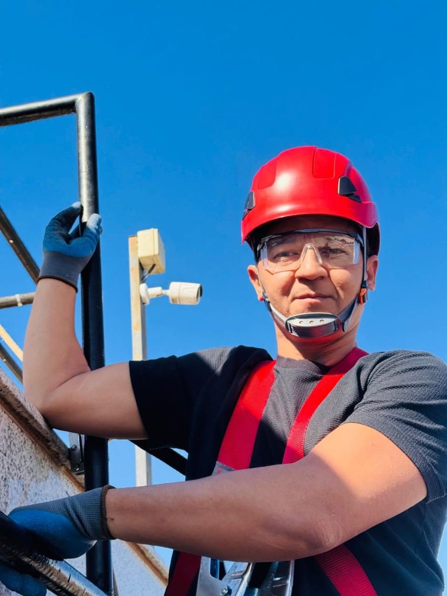 Eletricista da Só no Braço em trabalho em altura com capacete vermelho